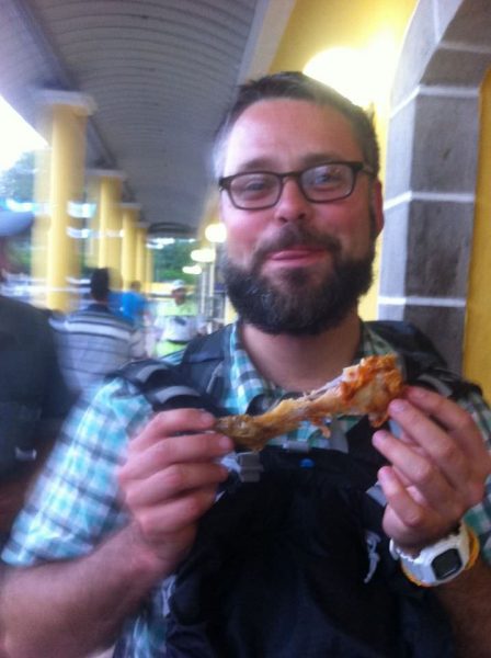 man eating fried chicken and smiling in Tecun Uman, Guatemala. CA-4 Visa Renewal - GreatDistances
