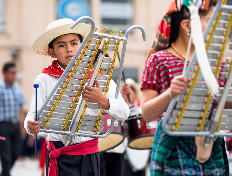 Boy with musical instrument in Guatemalan independence parade. Guatemalan Independence & Xela Feria 2014 - GreatDistances / Matt Wicks
