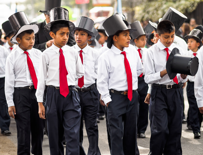 Boys with paper top hats in a Guatemalan independence parade in Xela. Guatemalan Independence & Xela Feria 2014 - GreatDistances / Matt Wicks