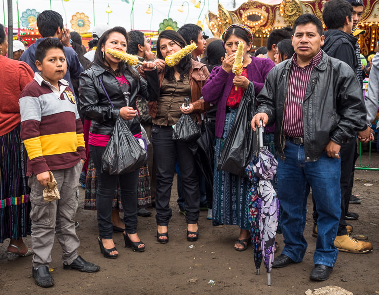 A family eating corn together at the Xela Feria in Quetzaltenango, Guatemala. Guatemalan Independence & Xela Feria 2014 - GreatDistances / Matt Wicks