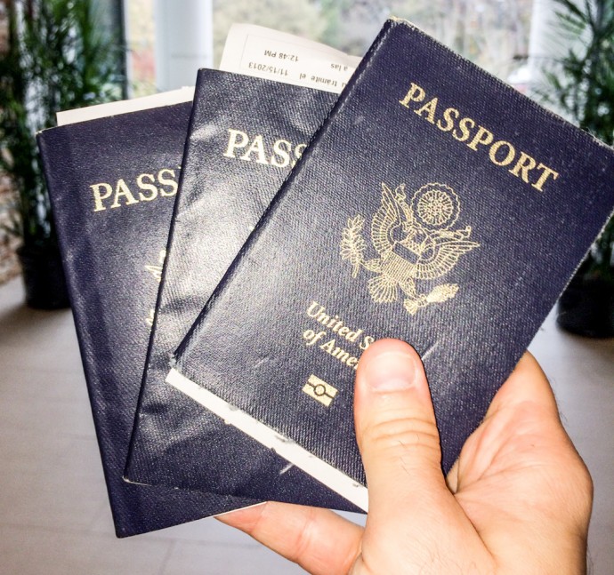 Hand holding three US Passports - two passports at once - GreatDistances / Matt Wicks