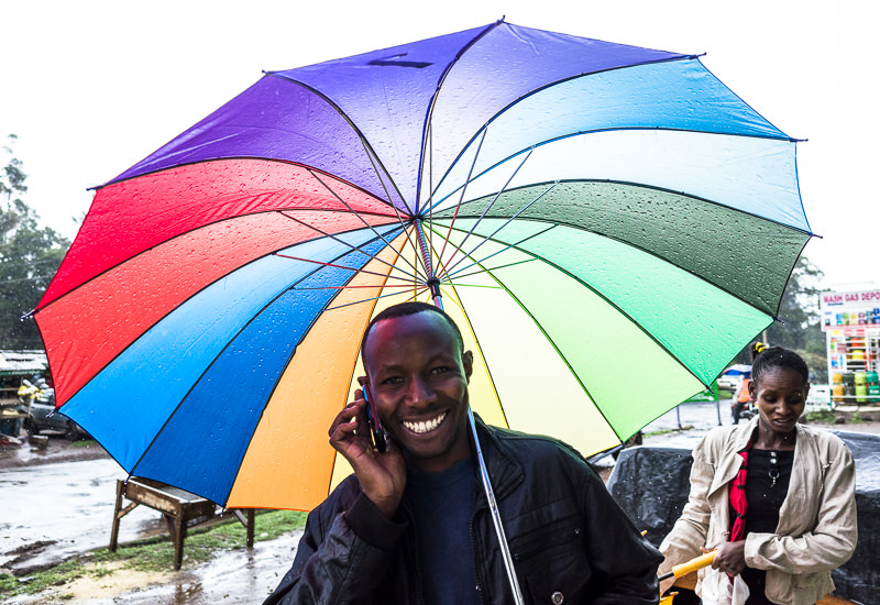 man with rainbow colored umbrella in Nanyuki, Kenya. GreatDistances / Matt Wicks