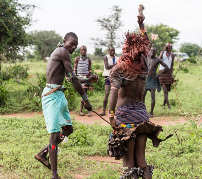 A whipper lashes a woman with his full strength at a Hamar Bull Jumping Ceremony. South Omo Part 2 - GreatDistances / Matt Wicks